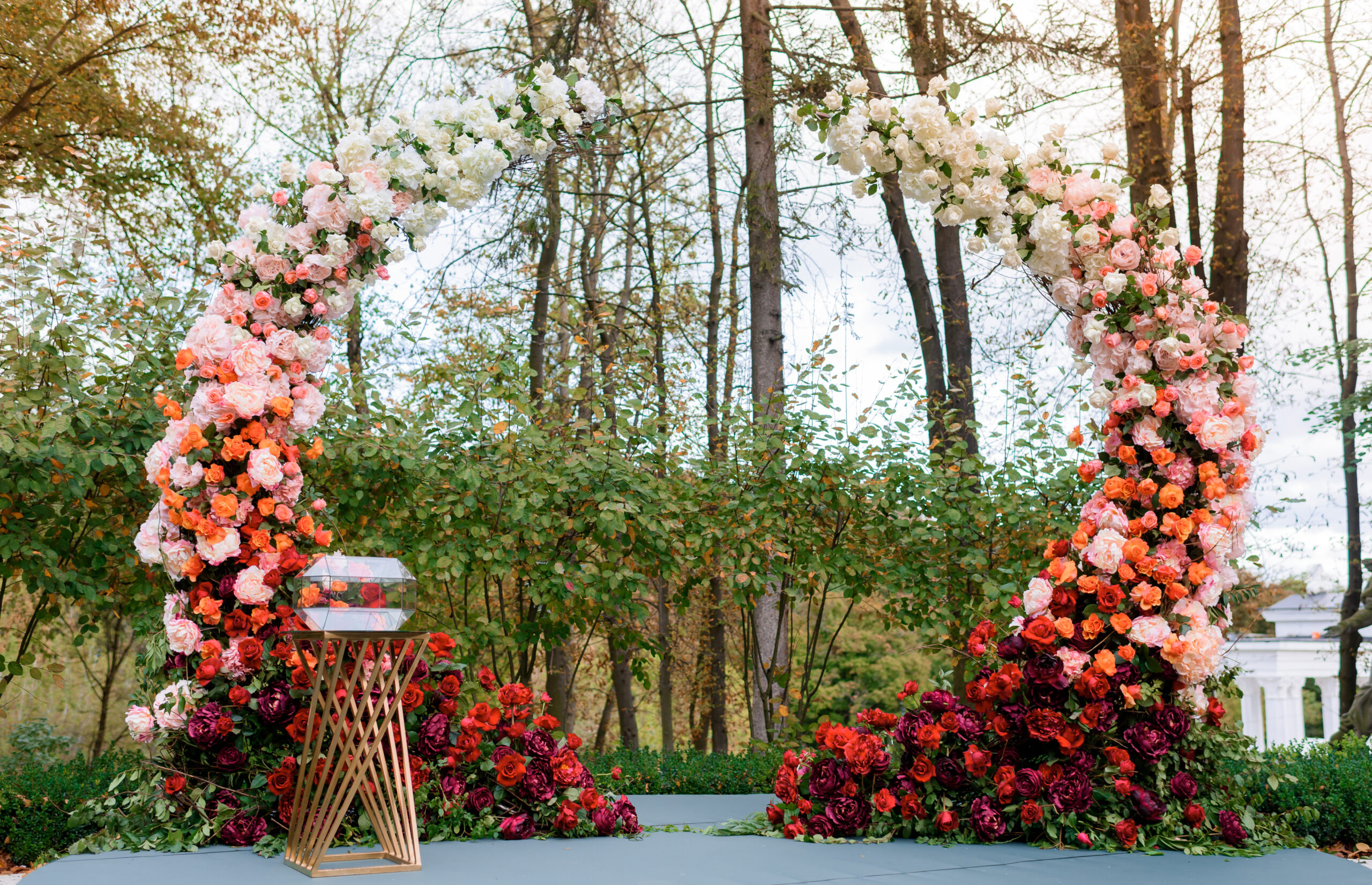 Front view of rich arch decorated with adorable fresh roses flowers. Concept of wedding ceremony details.